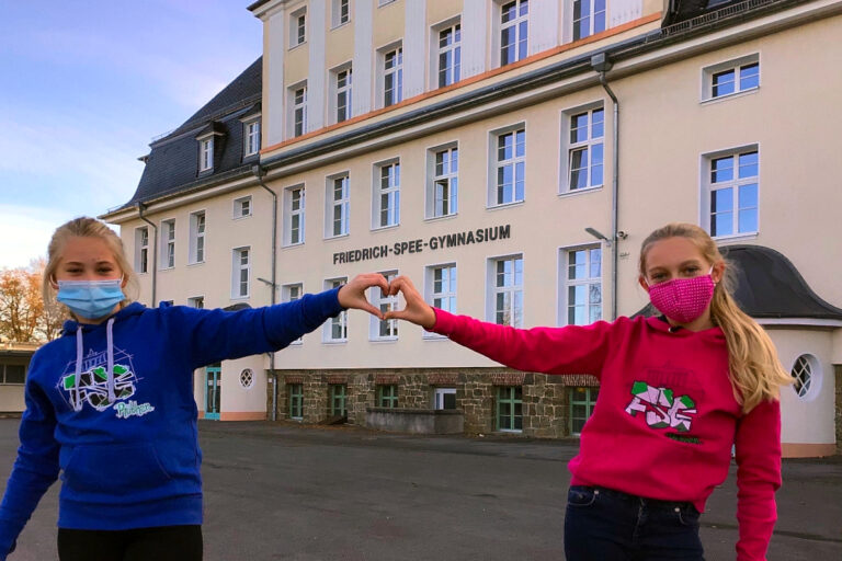 Schülerinnen vor dem Schulgebäude