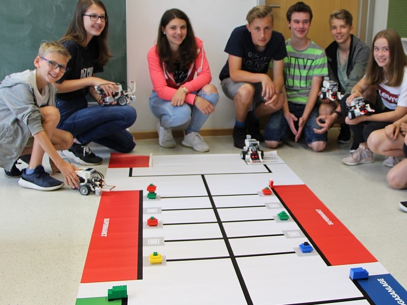 Schüler*innen mit Roboter*innen