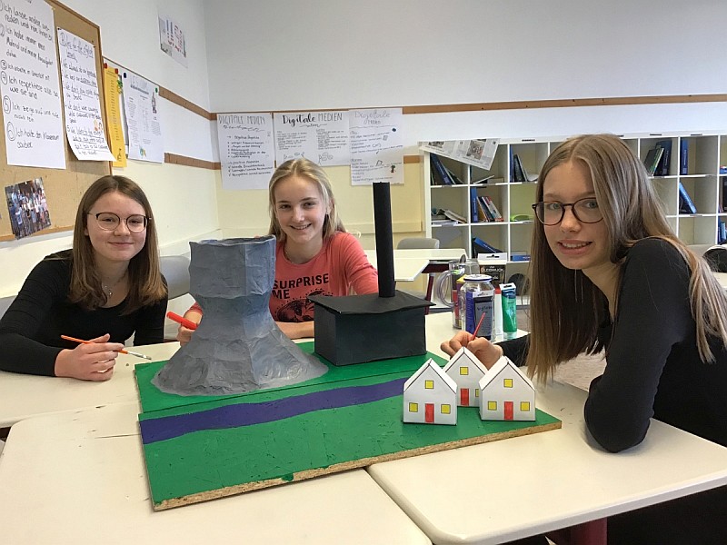 Mädchen mit Modell eines Kraftwerks